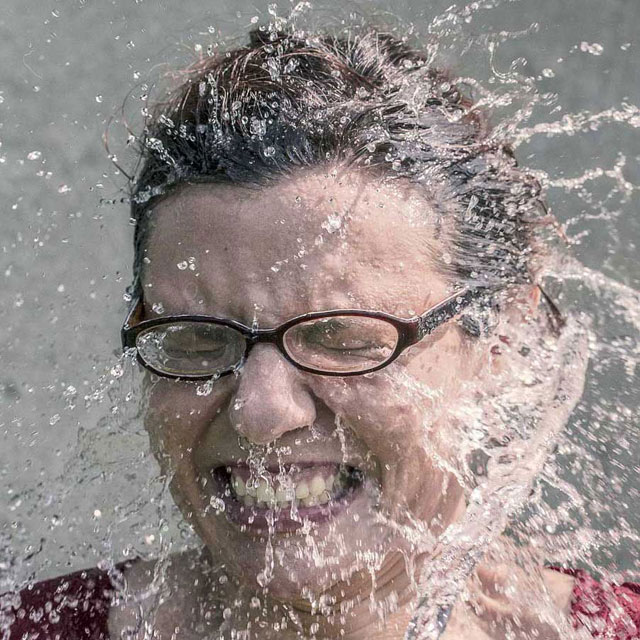 Woman with a face full of water from bucket of water